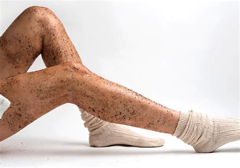 Femme appliquant un gommage au marc de café sur ses jambes