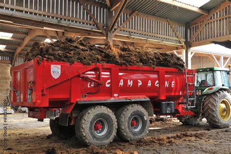 Tracteur avec benne à fumier en action dans un champ