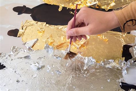 Artisan doreur travaillant une feuille d'or avec une palette