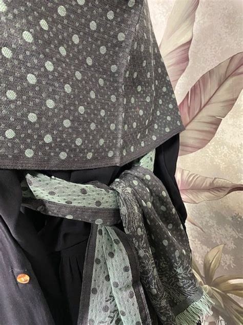 Gros plan sur une broche élégante fixant un châle pashmina sur l'épaule