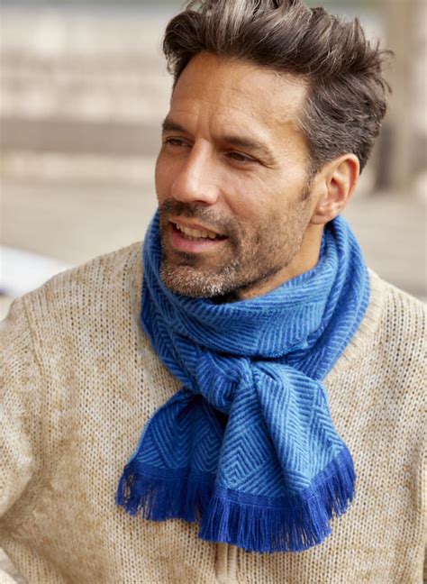 Homme portant un pashmina comme une écharpe volumineuse avec un manteau élégant