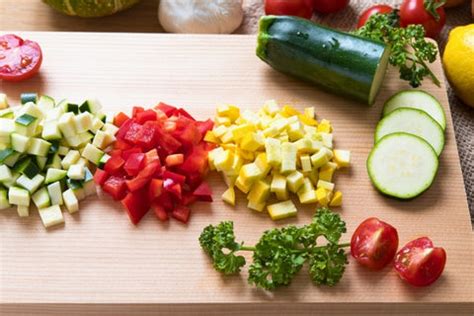 légumes de saison coupés en dés réguliers prêts à être cuisinés dans une sauteuse