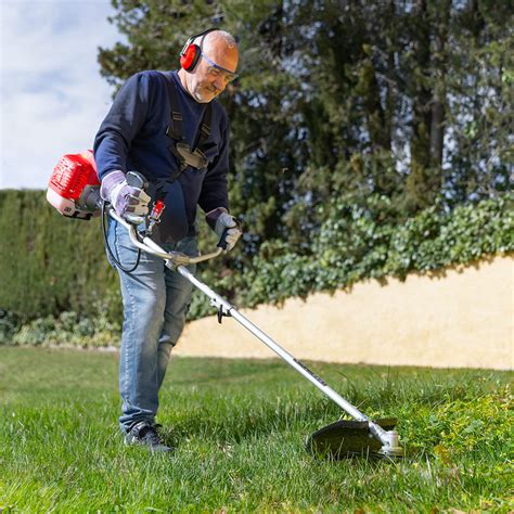 Débroussailleuse Greencut 65cc en action sur un terrain envahi par les herbes hautes