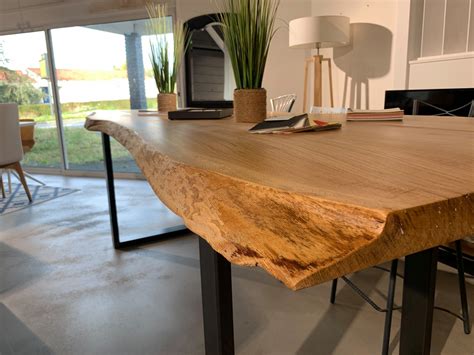 Table rectangulaire rustique en bois brut avec plateau en lattes et grillage métallique sur une terrasse