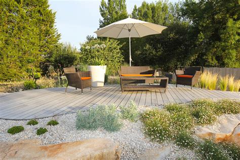 Vue panoramique du jardin clos avec la terrasse en bois et le mobilier de jardin