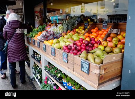 Photo d'un petit étalage de légumes frais sur une table devant une maison.