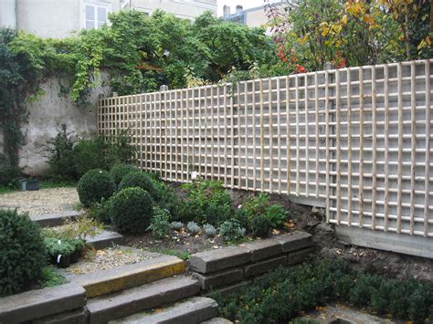 Treillage en bois fixé à un mur avec un rosier grimpant