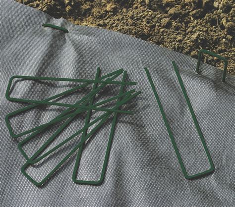 Illustration montrant l'utilisation polyvalente des agrafes : fixation de gazon artificiel, toile de paillage et bordure de jardin