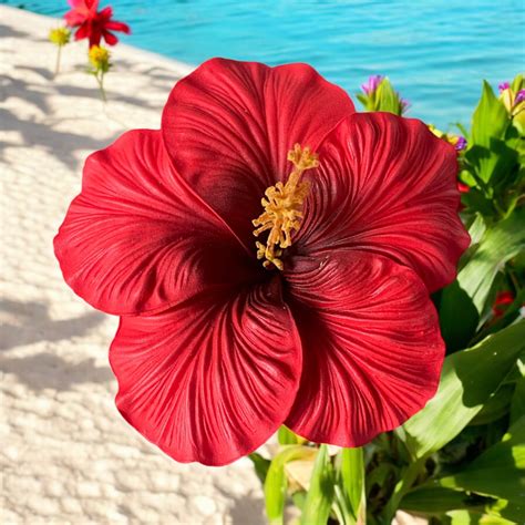 Un hibiscus artificiel rouge cerise posé sur une console en bois moderne