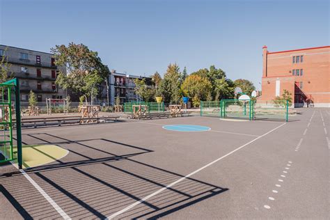 Un jardin pédagogique coloré au sein d'une cour d'école accueillant des enfants