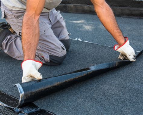 Application d'une émulsion asphaltée sur un talus fraîchement ensemencé.