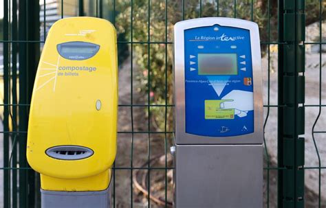 Anciennes bornes de compostage de billets de train SNCF sur un quai de gare.