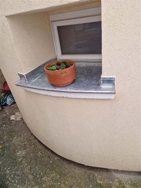 Plantoir ovale en zinc sur un rebord de fenêtre ensoleillé