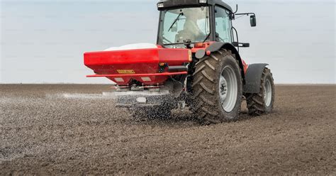 Tracteur avec épandeur à semences en plein champ