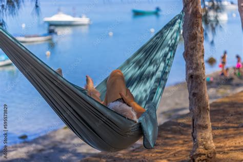 personne se relaxant dans un hamac sous un figuier