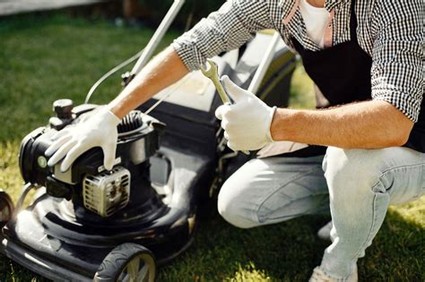 Personne nettoyant une tondeuse à gazon
