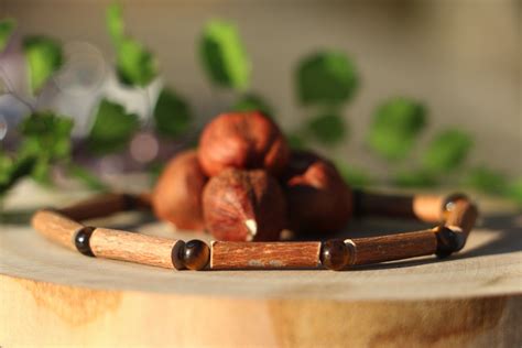 Illustration conceptuelle d'un collier en bois de noisetier posé sur une surface naturelle
