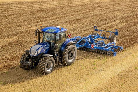 Tracteur New Holland en action dans un champ avec un épandeur