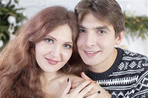 Couple avec une femme plus âgée et un homme plus jeune dans un jardin, l'homme taillant un buisson