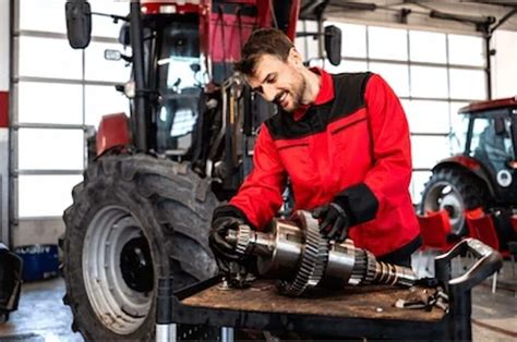 mécanicien agricole intervenant sur un tracteur dans un atelier