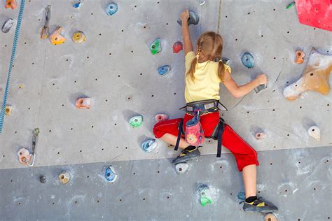 Enfant escaladant un mur de blocs en salle