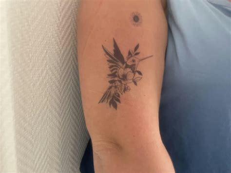 Tatouage monochrome de colibri et fleur d'hibiscus sur la peau