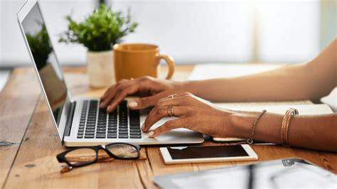 Une main écrivant un email sur un ordinateur portable