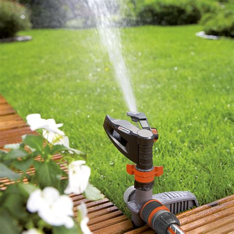 Photographie d'un arroseur à canon rotatif en fonctionnement dans un jardin