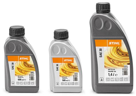 Bidons d'huile moteur SAE 30 et SAE 20 aux côtés d'une motobineuse vintage