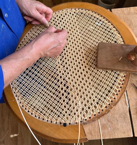 Vue d'ensemble d'un atelier de cannage avec les outils rangés proprement sur un établi en bois