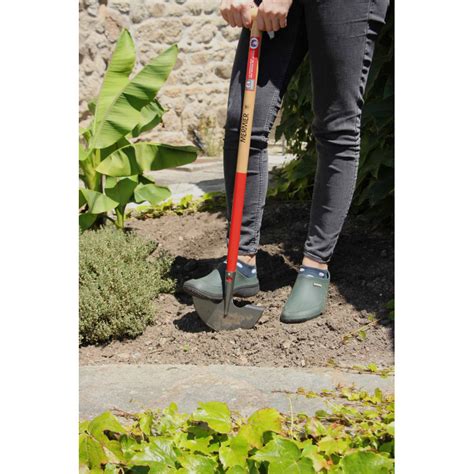 Un jardinier utilisant un dresse-bordure pour une bordure nette