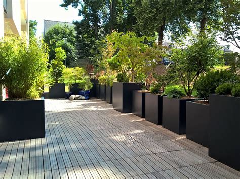 Une jardinière EDA Graphit disposée sur une terrasse moderne avec des plantes vertes