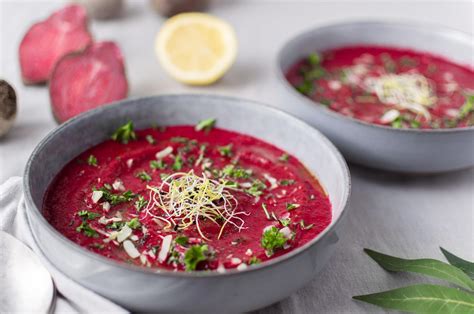 Bol de soupe veloutée à la betterave et au poireau, couleur pourpre intense et garniture d'herbes fraîches
