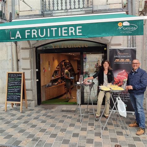 Vue de la vitrine de la Fruitière à Besançon avec ses étals de fromages