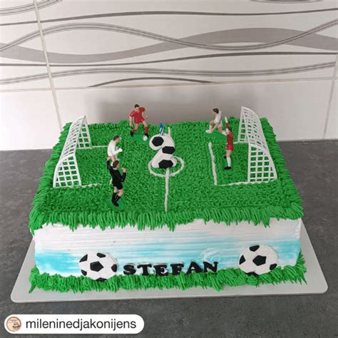 Gâteau d'anniversaire décoré en forme de terrain de football avec des figurines de joueurs et des cages de but.