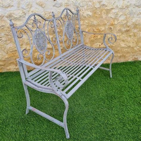 Ambiance de jardin avec un banc en fer forgé et des fleurs colorées