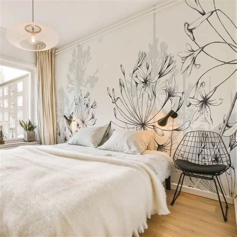 une chambre à coucher avec un papier peint floral bleu et des accessoires en bois clair