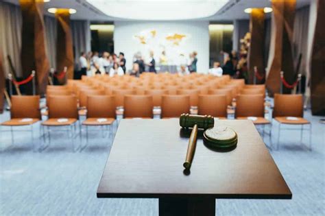 Vue intérieure d'une salle de vente aux enchères professionnelle avec des commissaires-priseurs en pleine action.