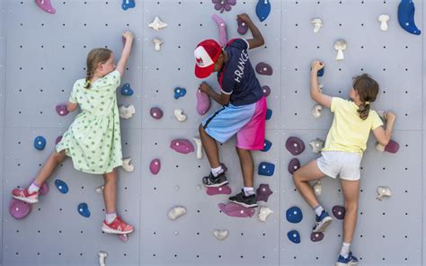 Groupe d'adolescents grimpant sur un mur d'escalade coloré