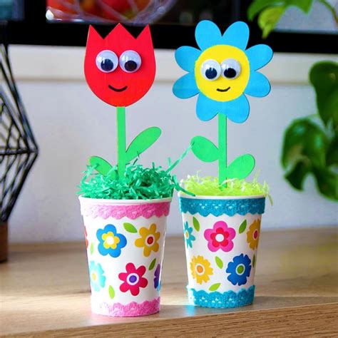 Enfants décorant des pots de fleurs