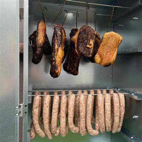 Image d'un fumoir avec bac à eau et thermomètre inséré dans une pièce de viande