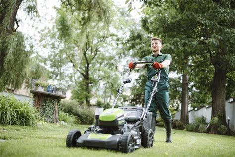 Un jardinier passant la tondeuse dans un cadre résidentiel verdoyant