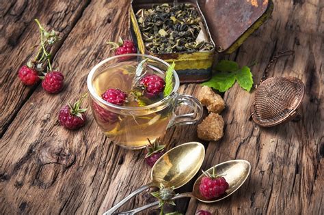 Tasse de tisane de feuilles de framboisier fumante sur une table en bois rustique
