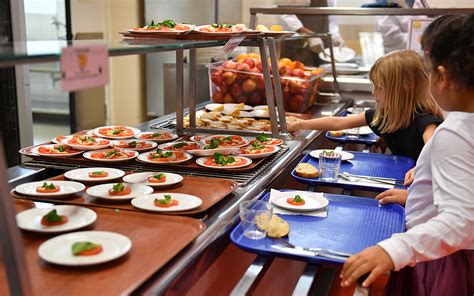 Enfants déjeunant à la cantine scolaire avec des produits locaux