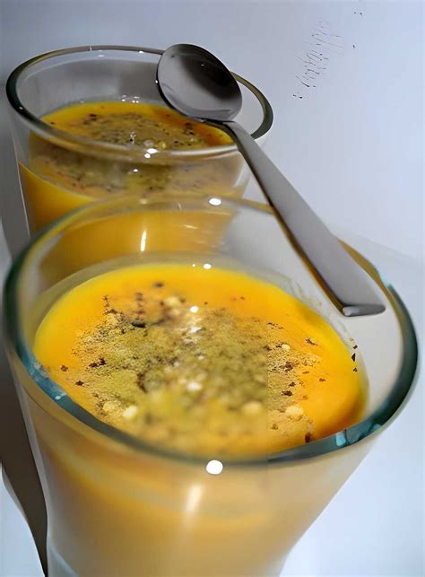 Bol de velouté de carottes à l'orange fumant avec une touche de crème et de coriandre fraîche