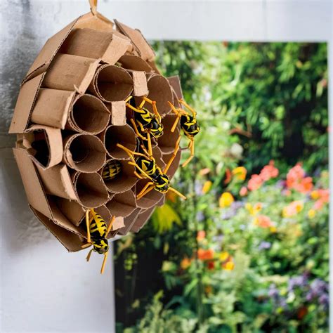 Jardinier installant un faux nid de guêpes en papier kraft