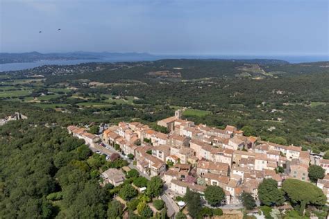 vue panoramique d'un village de Provence entouré de collines fleuries