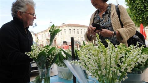 Personnes vendant du muguet dans la rue