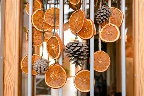 Guirlande de tranches d'oranges séchées et pommes de pin sur un support naturel