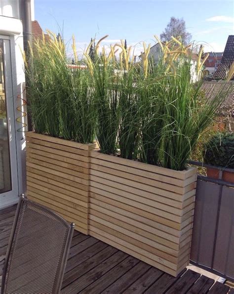 Balcon aménagé avec jardinières et brise-vue végétal